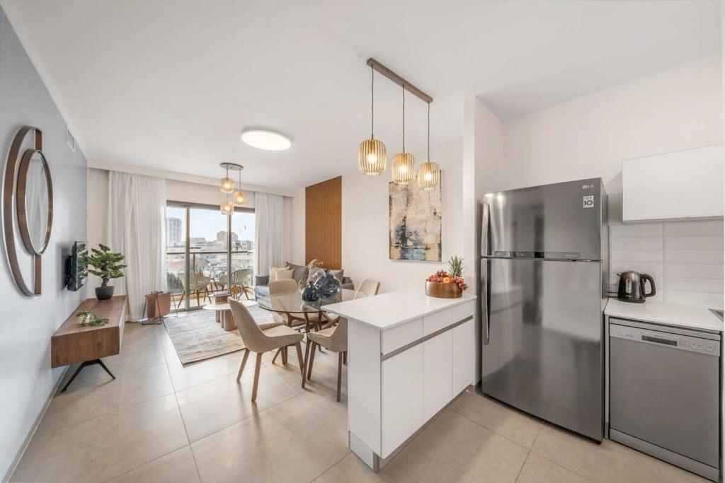 eine Küche mit einem Kühlschrank und einem Esszimmer in der Unterkunft Luxurious 1BDR Terrace Parking in City Central in Jerusalem