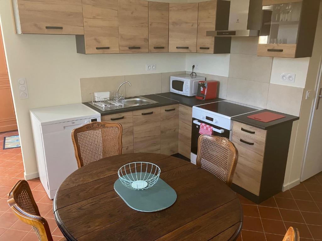 eine Küche mit einem Holztisch und eine Küche mit einem Waschbecken und einem Tisch in der Unterkunft La Glycine in Pézenas