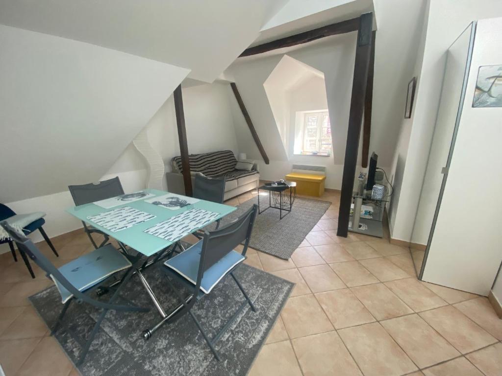 a dining room with a green table and chairs at Appartement de charme rue du Château in Auray
