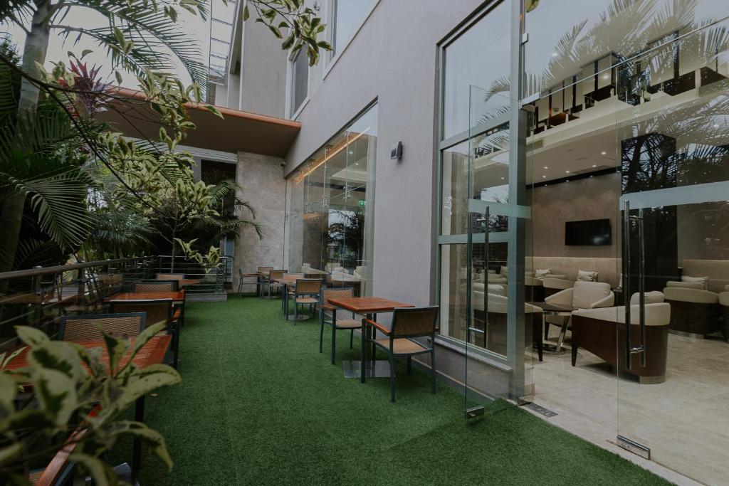 a restaurant with green flooring and tables and chairs at Crowne Plaza Nairobi Airport by IHG in Nairobi