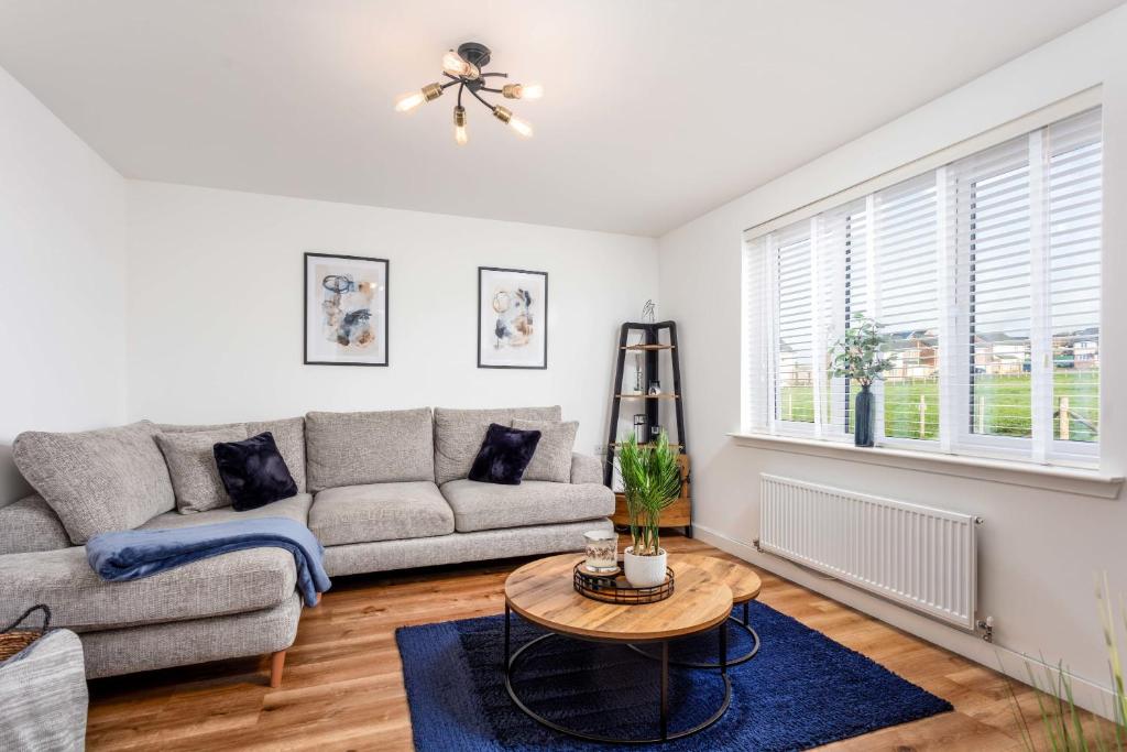 uma sala de estar com um sofá e uma mesa em 21 Ironfield Lane em Prestwick