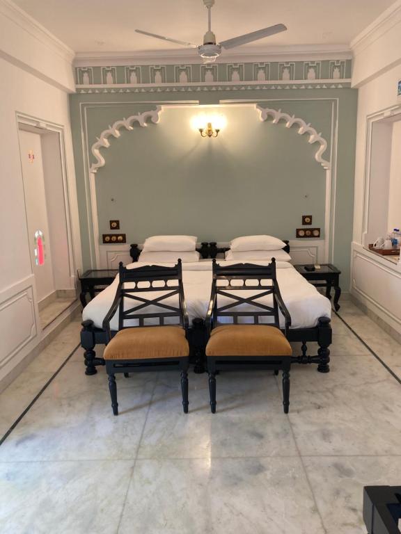 a bedroom with four beds and a ceiling at Amet Haveli in Udaipur