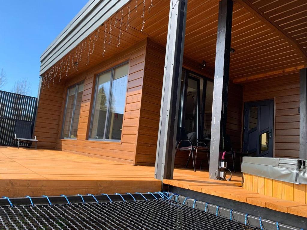 a house with a wooden deck with windows at Ecottage котедж для двох у горах із чаном-джакузі in Slavske