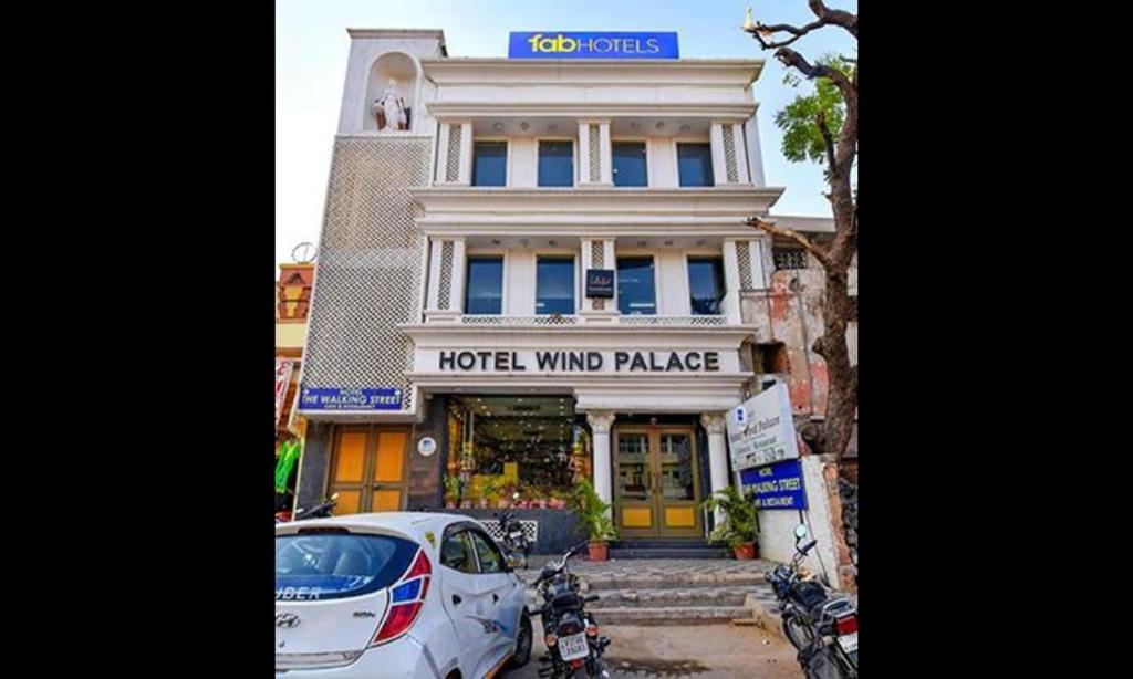 um carro branco estacionado em frente a um hotel palácio do vento em FabHotel The Wind Palace em Jaipur