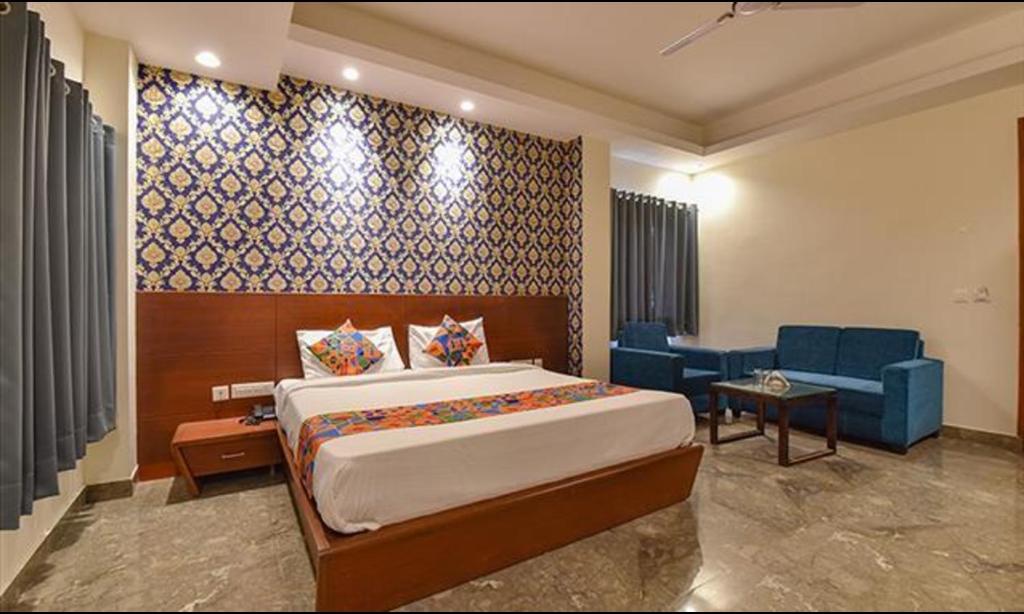 a bedroom with a bed and a couch and a chair at FabHotel The Wind Palace in Jaipur