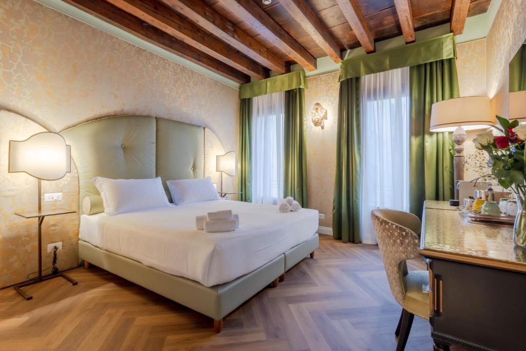 Habitación de hotel con cama, escritorio y cama en 312 Piazza San Marco en Venecia