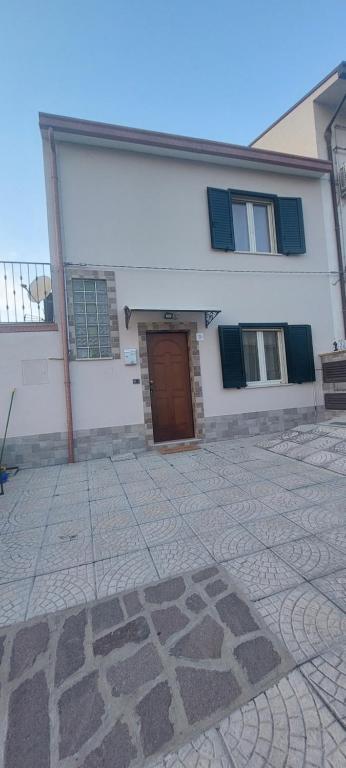 un edificio blanco con puerta marrón y patio de piedra en Casa MiDa vista panoramica sulla Maiella, en Castelfrentano