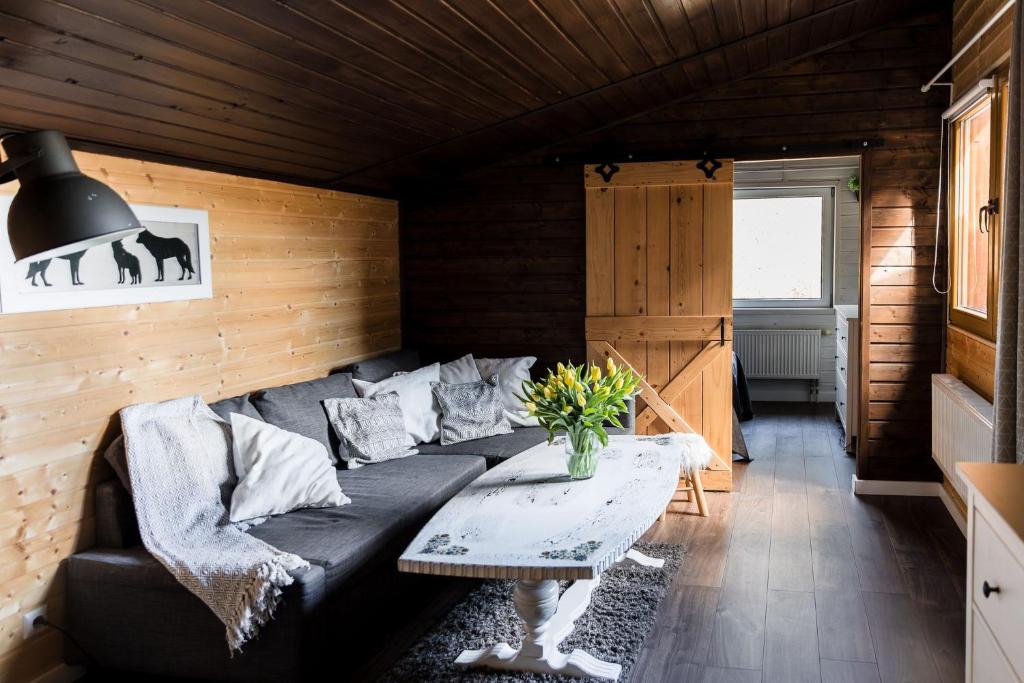 a living room with a black couch and a table at Pensjonat Laworta Ski in Ustrzyki Dolne
