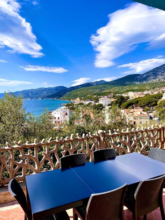 a blue table on a balcony with a view of the water at Appartamento Blue in Cala Gonone