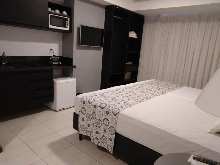 um quarto de hotel com uma cama e um lavatório em Flat decorado em localização excelente em Feira de Santana