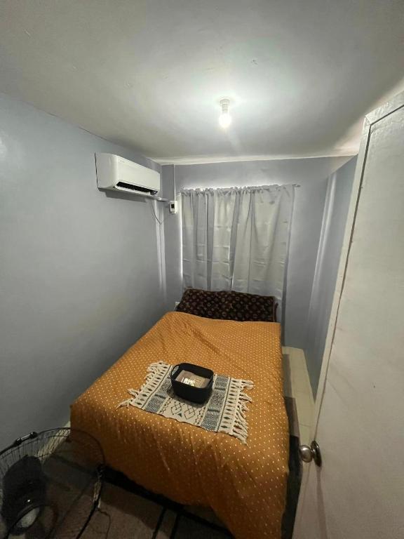 - un petit lit dans une petite chambre avec fenêtre dans l'établissement Butuan Cozy Riverhouse Transient, à Butuan