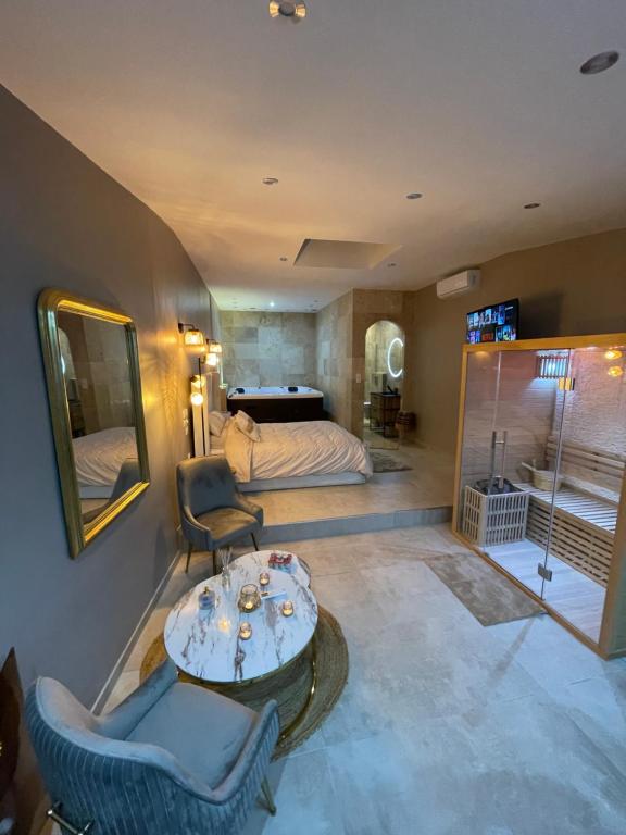 een slaapkamer met een bed en een tafel en stoelen bij La nuit de rêve Suite privative Jaccuzi Sauna Suite 2 in Crouy