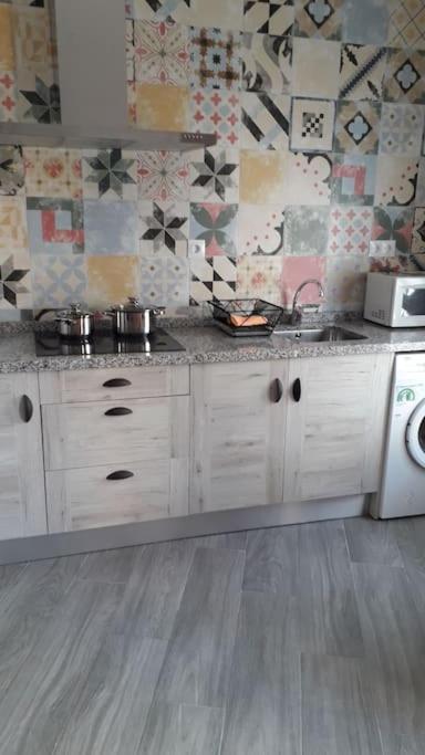 a kitchen with a sink and a washing machine at La Oficina in Fernán Pérez