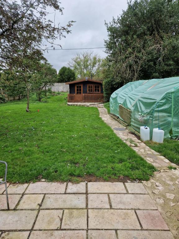 un jardin avec une tente et une maison dans l'établissement The Cabin - a very quiet location, à Pewsey