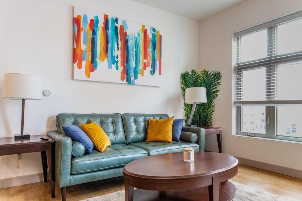 a living room with a green couch and a table at 2BR Luxury New Apartment with Outdoor Pool in Kansas City