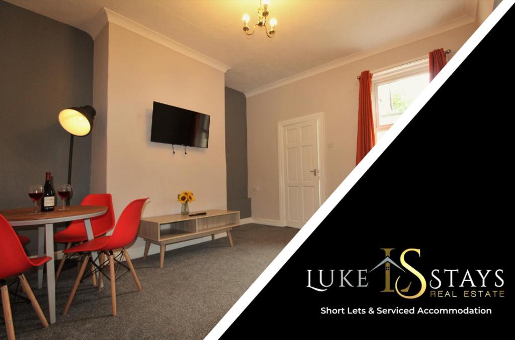 a living room with a table and red chairs at Luke Stays - Nicholson Terrace in Killingworth