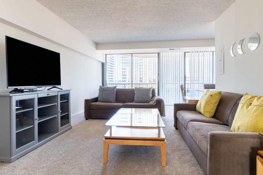 uma sala de estar com um sofá e uma televisão de ecrã plano em 2BR Serene Executive Retreat with Balcony em Arlington
