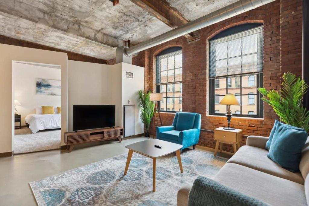 a living room with a couch and a tv at 2BR Historic Loft Retreat With Pool & Gym in Pittsburgh