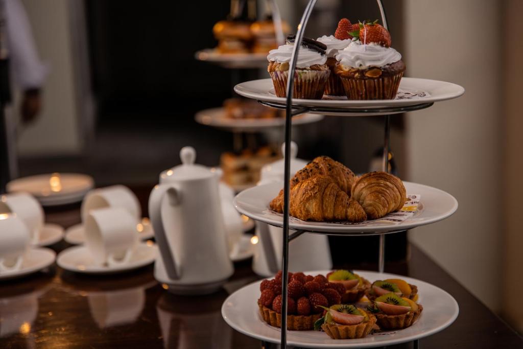 a table with three tiered plates of pastries and cupcakes at Crowne Plaza Nairobi Airport by IHG in Nairobi