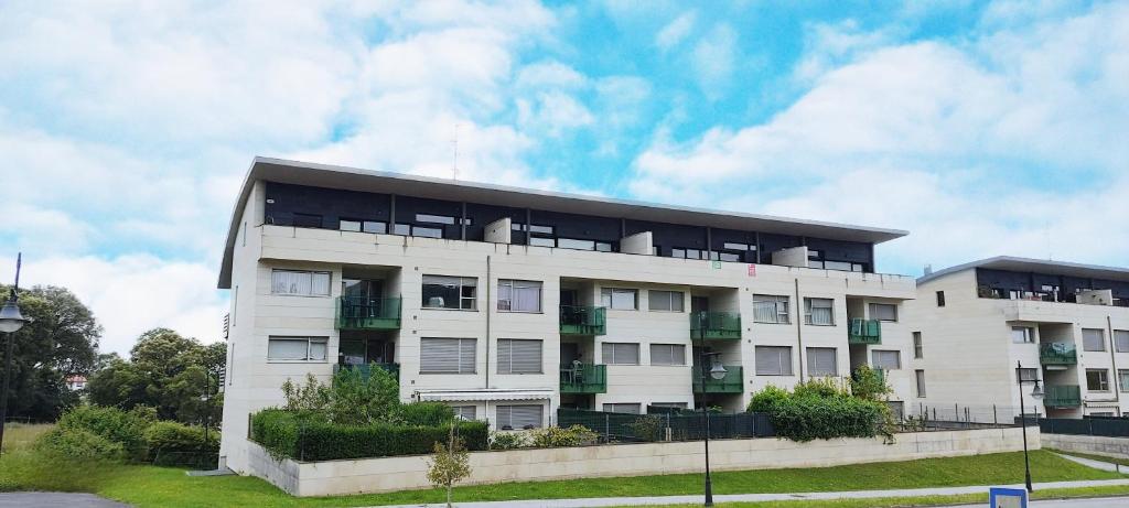 biały budynek apartamentowy z oknami na boku w obiekcie Apartamento La Arquera Golf 2 w mieście Llanes