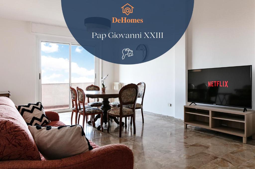 DeHomes - Papa Giovanni XXIII في بوكيناسكو: غرفة معيشة مع طاولة وكراسي وتلفزيون