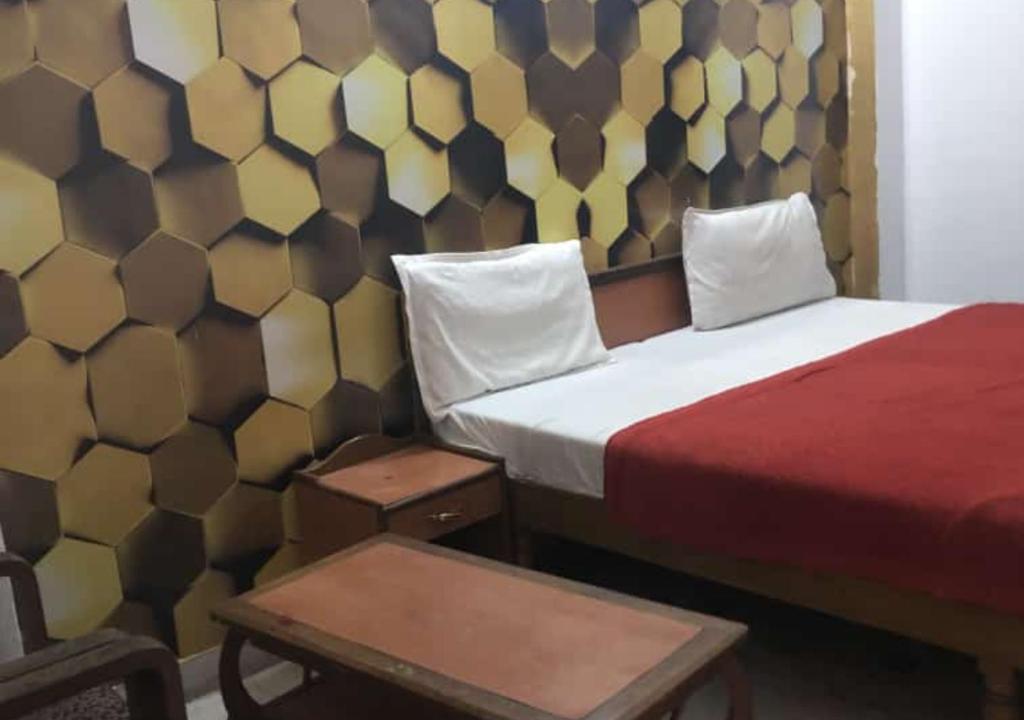 ハリドワールにあるHotel Shree Chitra Residency By Avadhesh Group of Hospitalityのベッドとテーブルが備わるホテルルームです。