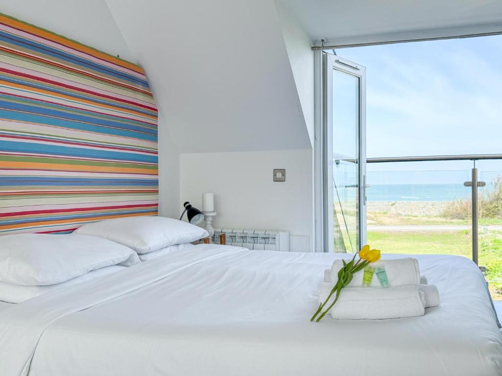 um quarto com uma cama branca e uma cabeceira listrada em Waves Guest Suites em Castel