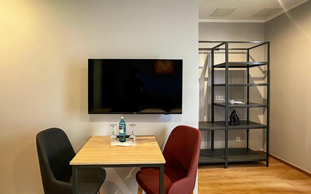 a dining room with a table and a tv on the wall at Trip Inn Hotel Düsseldorf Neuss in Neuss