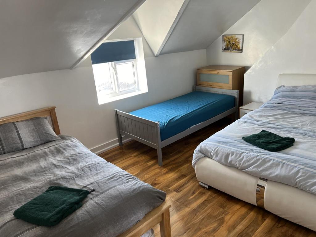 a attic bedroom with two beds and a window at TownHouse near Beach Bournemouth in Bournemouth