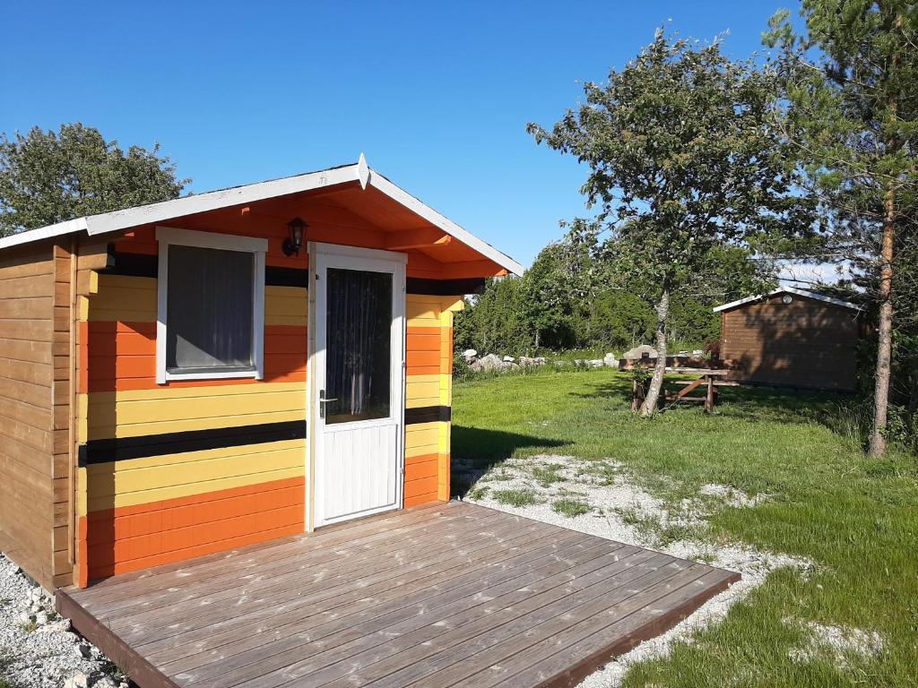 a colorful house with a deck in a field at Kadakasuitsu Loodustalu in Saareküla