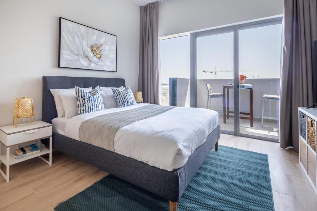 a bedroom with a large bed and a large window at Frank Porter - Azizi Aura in Dubai