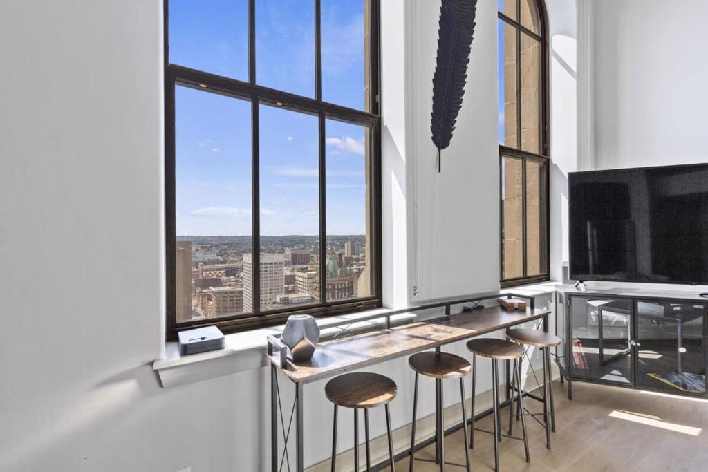 a bar with stools in a room with large windows at 2BR Luxury Apartment Rooftop Pool & Gym in Baltimore