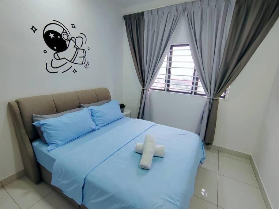 Un dormitorio con una cama con una toalla. en Traders Garden Cozy 2 BR Family Suite with WiFi Netflix, en Cheras