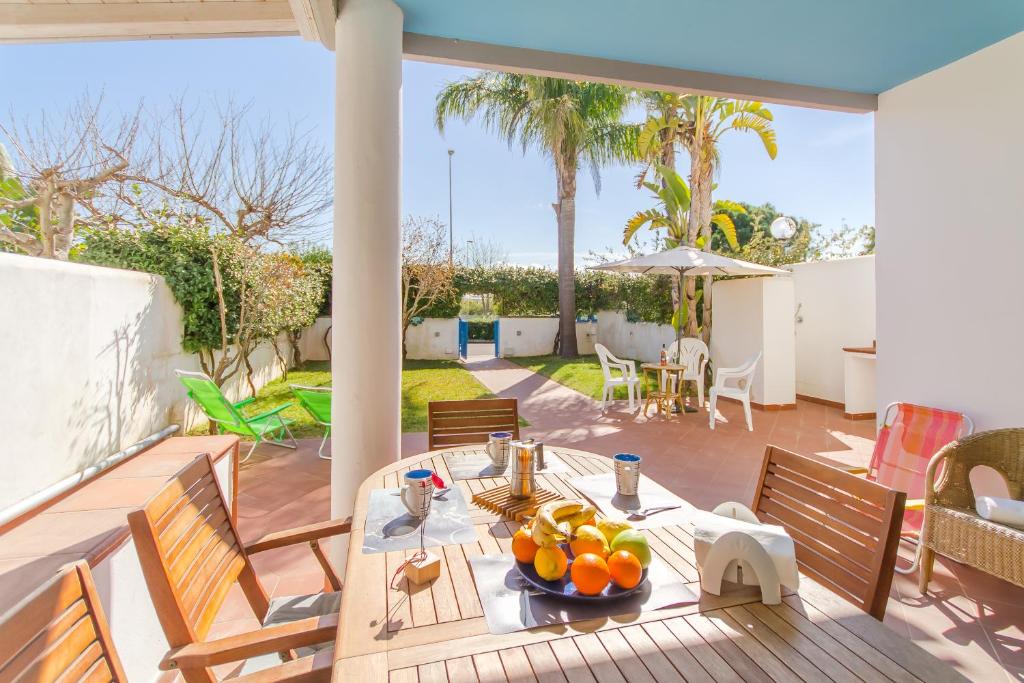 eine Terrasse mit einem Tisch und Orangen darauf in der Unterkunft Villetta Relax With Pool in Residence - Happy Rentals in Melendugno