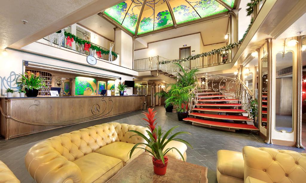 a lobby with a yellow couch and a glass ceiling at Hotel Relais Des Alpes in Madonna di Campiglio