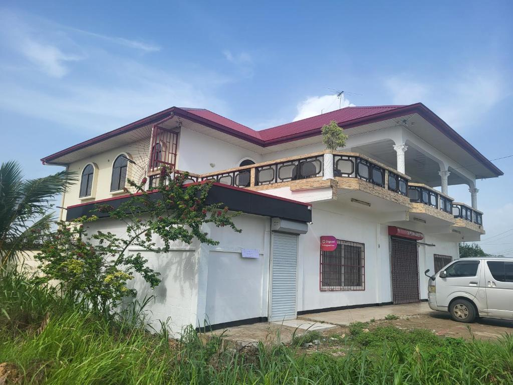 a white house with a balcony on top of it at Minia House in Flora