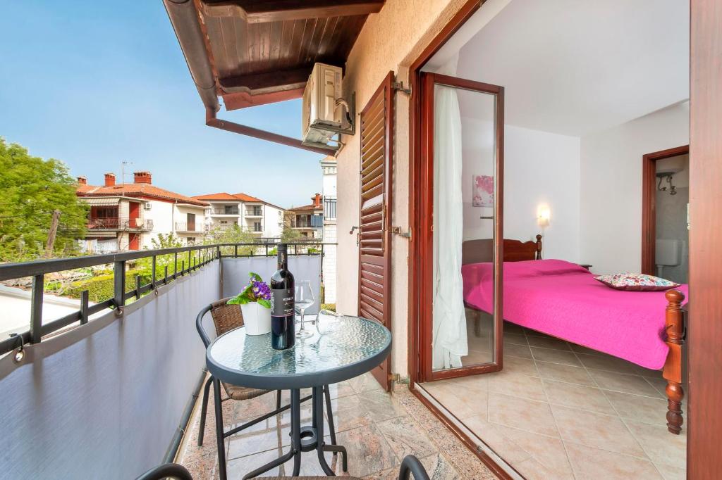 a balcony with a table and a bed on a balcony at Apartments and Room Silvana in Rovinj