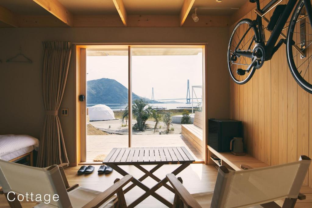 a bike hanging on the wall in a room with a table and chairs at WAKKA in Imabari