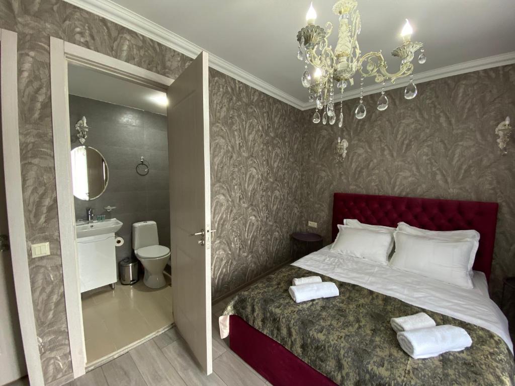 1 dormitorio con cama y lámpara de araña en Sunny City en Borjomi
