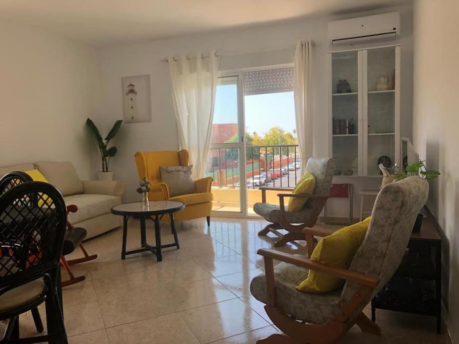 een woonkamer met stoelen, een bank en een tafel bij Resplandeciente Apto Cerca de la Playa en Isla Cristina by Batuecas in Isla Cristina