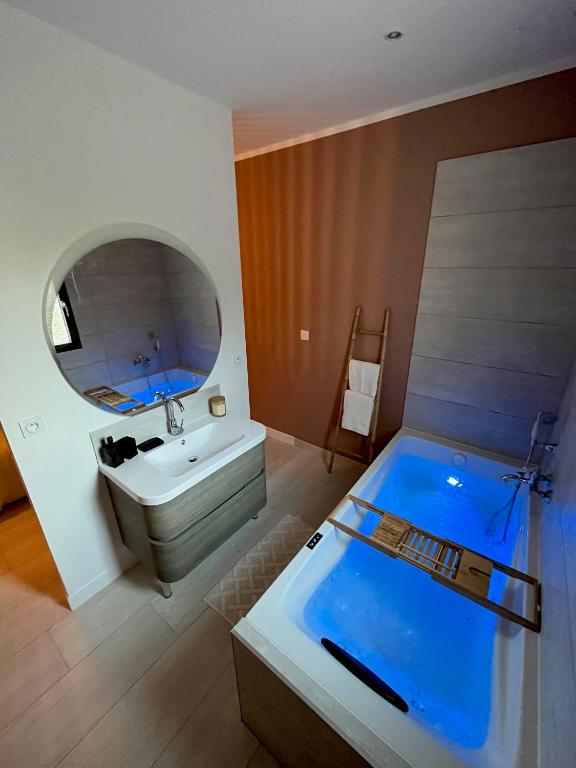 une salle de bain avec une baignoire, un lavabo et un miroir dans l'établissement Maison d’exception, à Monteux