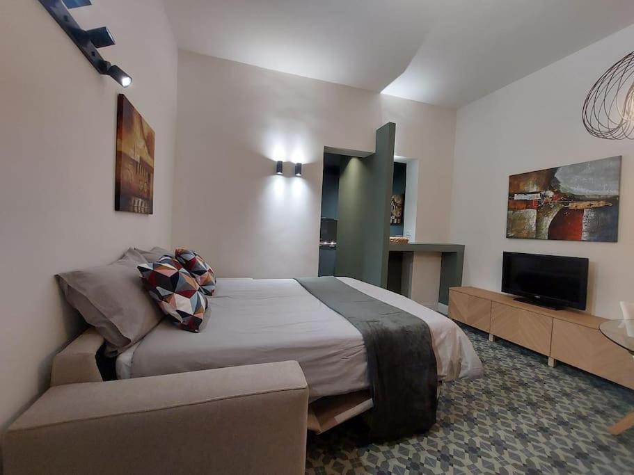 ein Schlafzimmer mit einem großen Bett und einem Sofa in der Unterkunft Green Apartment - City Centre in Genua
