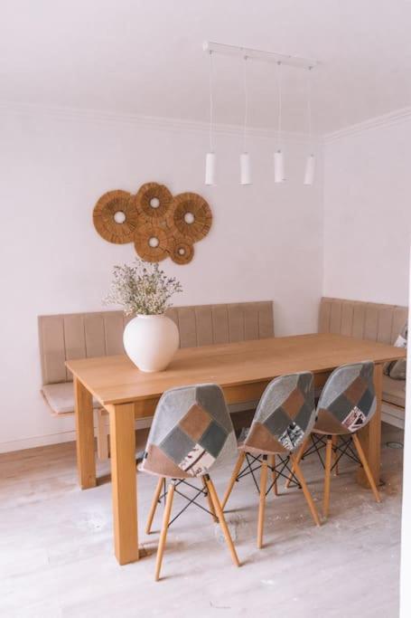 a wooden table with two chairs and a vase on it at Casa Azul in Trafaria