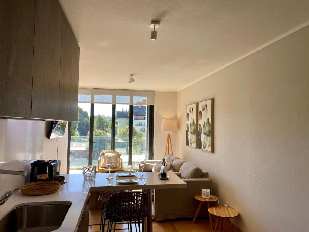 a kitchen with a sink and a living room at Depto TOP1 con Estacionamiento en Puerto Varas in Puerto Varas