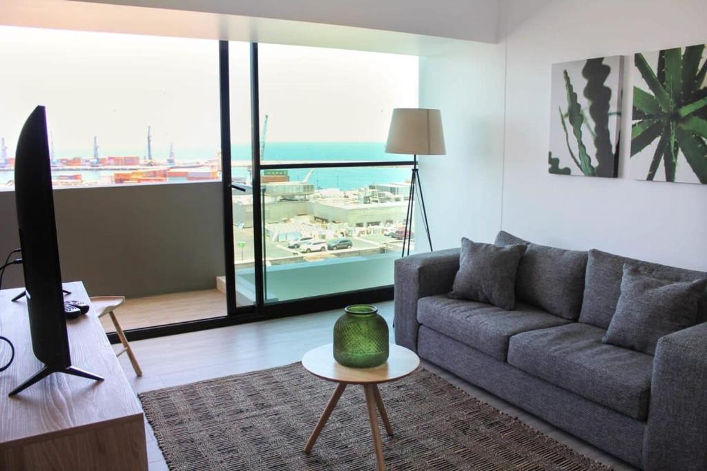sala de estar con sofá y mesa en Departamento 1D1B con Terraza vista al Mar Servicio HOM 0810, en Antofagasta