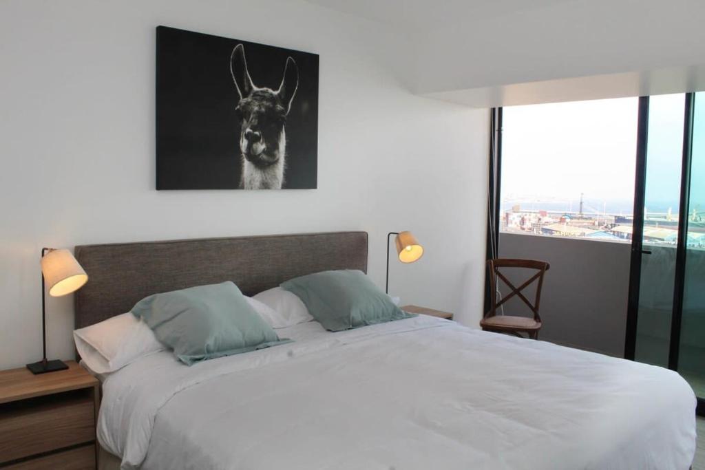 Un dormitorio con una cama con una foto de una llama en Espectacular Depto 1D1B, y Estacionamiento Privado Servicio HOM, en Antofagasta