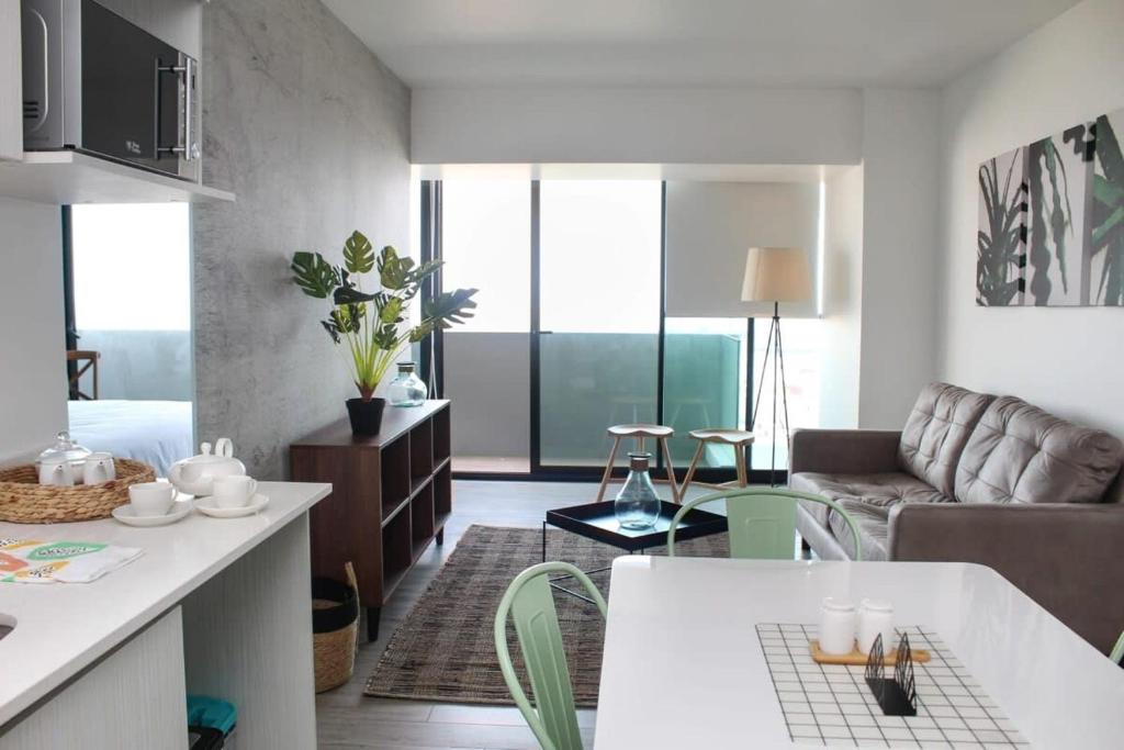 uma cozinha e sala de estar com um sofá e uma mesa em Espectacular Depto 1D1B, y Estacionamiento Privado Servicio HOM em Antofagasta