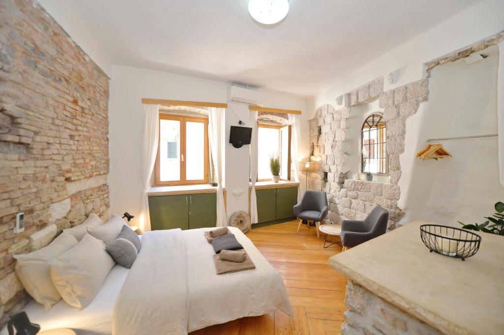 a bedroom with a bed and a brick wall at Charming apartment in Kotor in Kotor