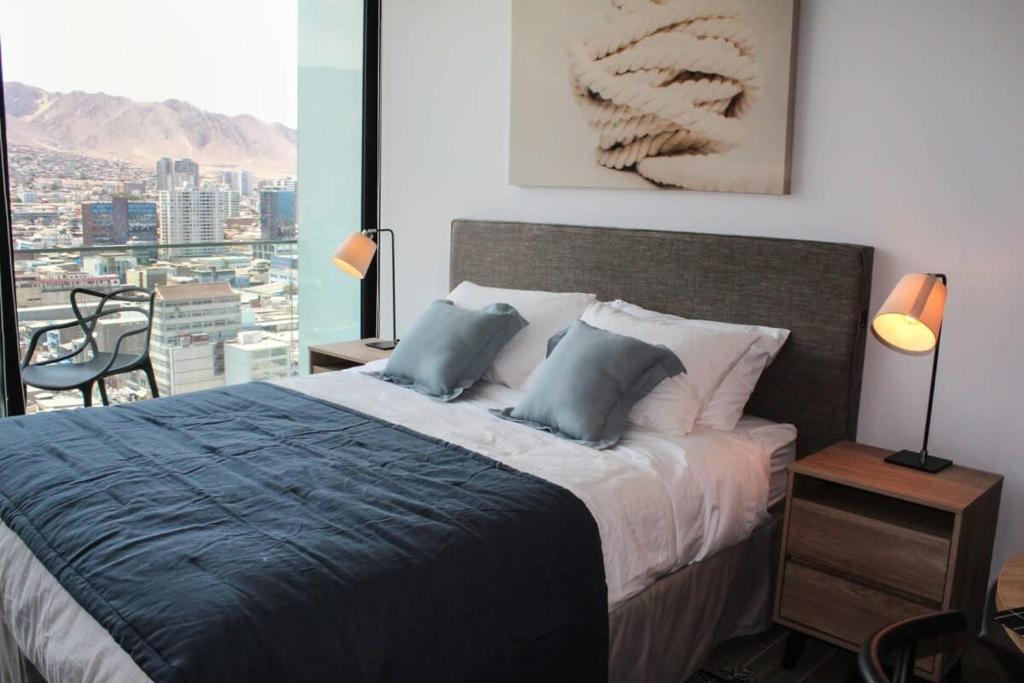 una camera con letto e vista sulla città di HOM I Departamento Estudio en Mejor Zona Frente al Mall 1218 ad Antofagasta