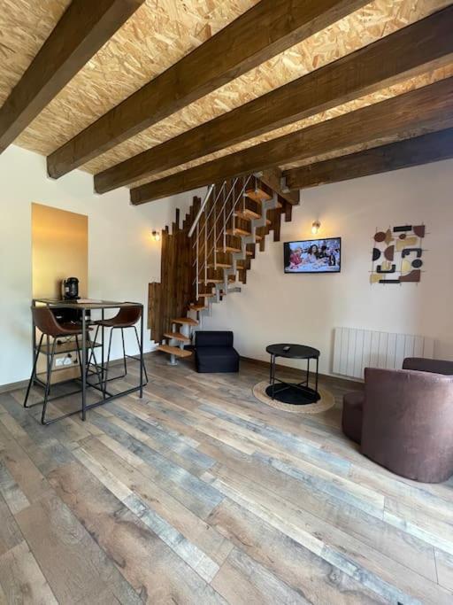 ein Wohnzimmer mit einem Tisch und einer Treppe in der Unterkunft Le duplex de vos rêves in Saint-Dizier